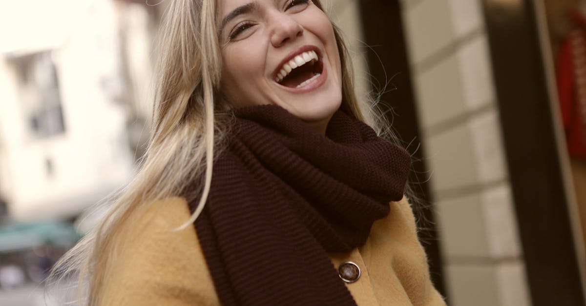 Vibrant portrait of a joyful woman laughing outdoors in winter clothing. Radiates happiness.